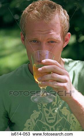 Stock Image - Young male drinking from glass. Fotosearch