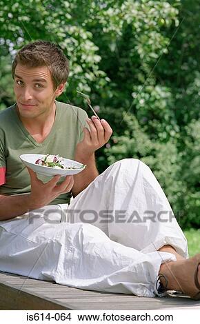 Young male eating outdoors View Large Photo Image Picture - Young male eating outdoors. Fotosearch
