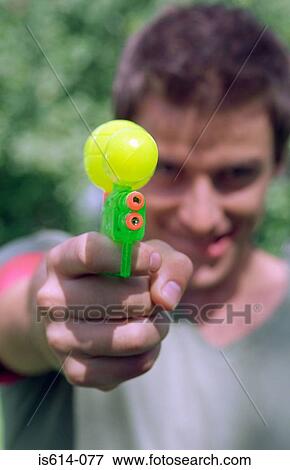 Young man aiming water pistol. View Large Photo Image Stock Photo - Young man aiming water pistol.. Fotosearch