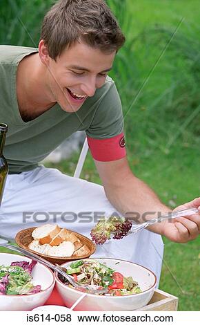 Young man at al fresco lunch. View Large Photo Image Stock Photo - Young man at al fresco lunch.. Fotosearch