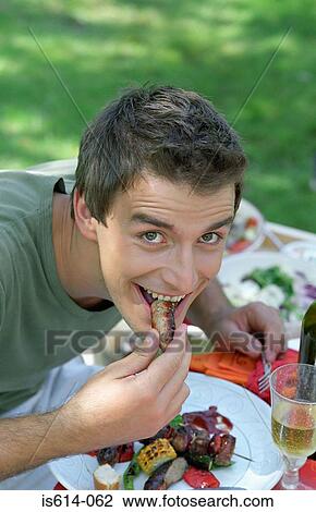 Young man at al fresco meal. View Large Photo Image Stock Image - Young man at al fresco meal.. Fotosearch