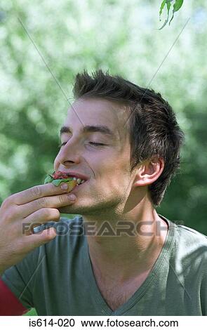 Young man enjoying food. View Large Photo Image Stock Image - Young man enjoying food.. Fotosearch