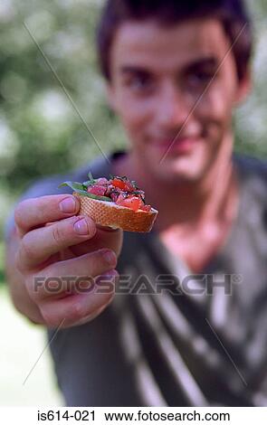 Young man offering food. View Large Photo Image Stock Image - Young man offering food.. Fotosearch