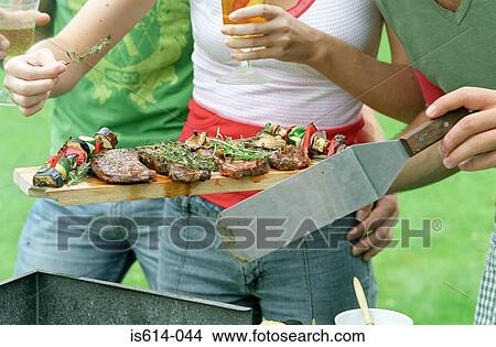 Picture - Young people having a barbeque. Fotosearch