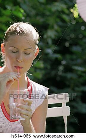Stock Photography - Young woman sipping drink.. Fotosearch