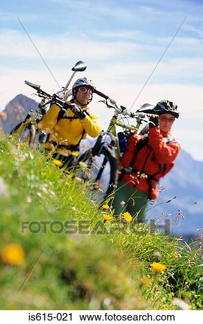 Carrying bikes across hillside. View Large Photo Image Stock Image - Carrying bikes across hillside.. Fotosearch