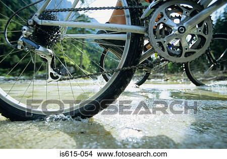 Cyclists crossing stream. View Large Photo Image Picture - Cyclists crossing stream.. Fotosearch