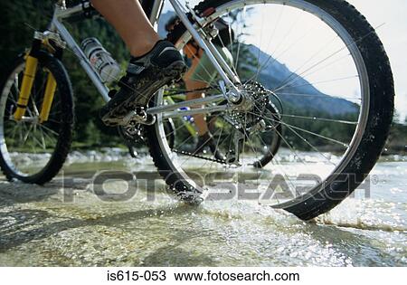 Cyclists crossing stream. View Large Photo Image Stock Image - Cyclists crossing stream.. Fotosearch