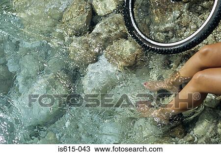 Stock Image - Female cyclist cooling feet.. Fotosearch