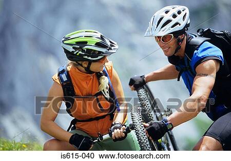 Smiling cyclists inflating tyre. View Large Photo Image Stock Image - Smiling cyclists inflating tyre.. Fotosearch