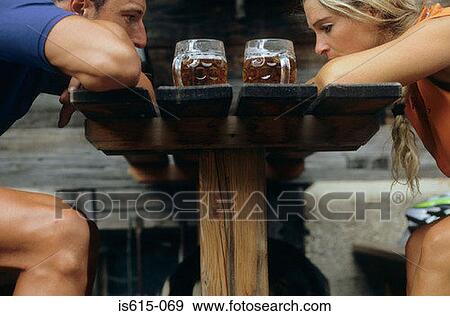 Stock Photo - Tired cyclists sit with beers.. Fotosearch