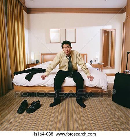 Businessman sitting on edge of bed View Large Photo Image Stock Photo - Businessman sitting on edge of bed. Fotosearch