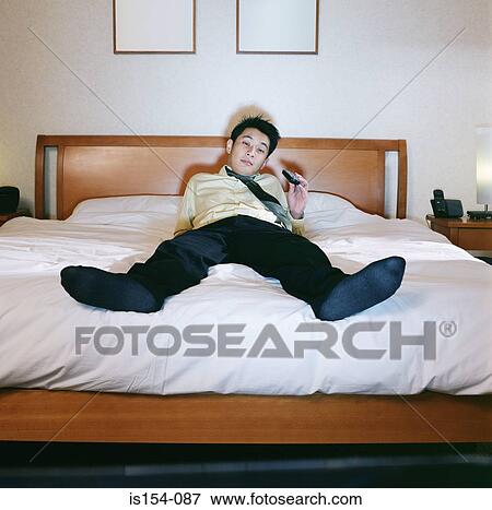 Businessman watching television View Large Photo Image Stock Photo - Businessman watching television. Fotosearch