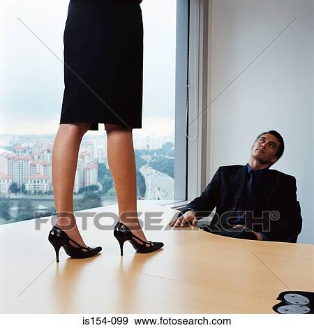 Businessman watching woman on desk View Large Photo Image Stock Photo - Businessman watching woman on desk. Fotosearch