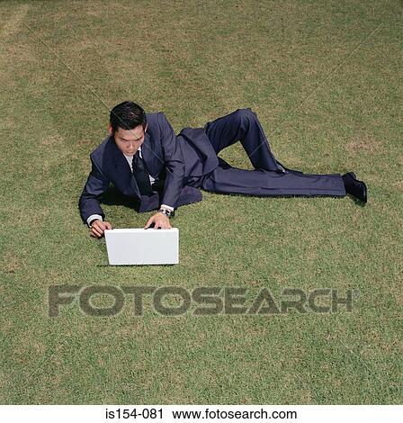 Stock Image - Businessman working in a field. Fotosearch