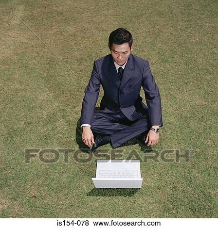 Businessman working in a field View Large Photo Image Stock Photo - Businessman working in a field. Fotosearch