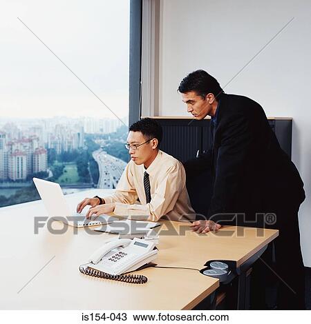 Stock Image - Businessmen working in office. Fotosearch