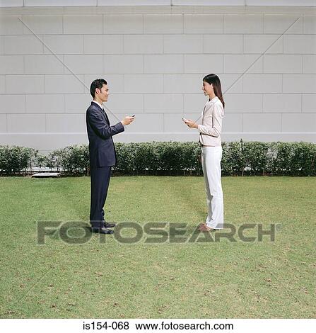 Stock Photo - Businesspeople text messaging. Fotosearch