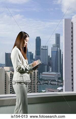 Businesswoman writing in notebook View Large Photo Image Stock Image - Businesswoman writing in notebook. Fotosearch