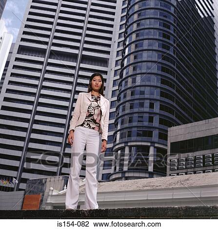 Woman standing near skyscrapers View Large Photo Image Stock Image - Woman standing near skyscrapers. Fotosearch