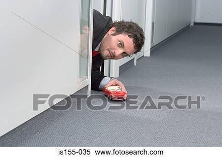 Businessman playing with toy car View Large Photo Image Stock Photography - Businessman playing with toy car. Fotosearch