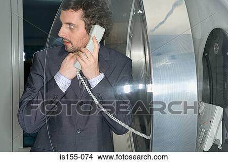 Businessman using pay telephone View Large Photo Image Picture - Businessman using pay telephone. Fotosearch
