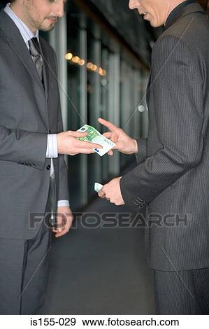 Businessmen exchanging money View Large Photo Image Stock Photo - Businessmen exchanging money. Fotosearch