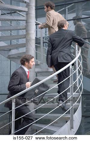 Businessmen running up spiral staircase View Large Photo Image Stock Photo - Businessmen running up spiral staircase. Fotosearch