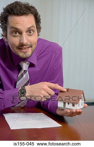 Stock Photography - Estate agent with model house. Fotosearch