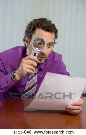 Man reading document with magnifying glass View Large Photo Image Stock Photograph - Man reading document with magnifying glass. Fotosearch