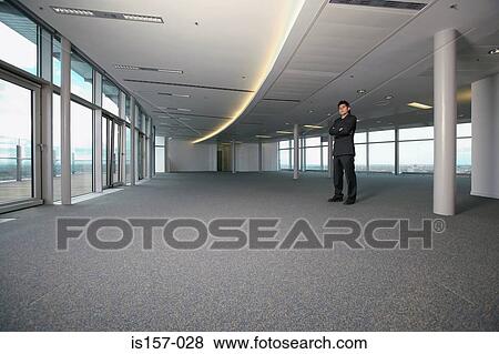 Asian businessman in empty office View Large Photo Image Stock Photo - Asian businessman in empty office. Fotosearch