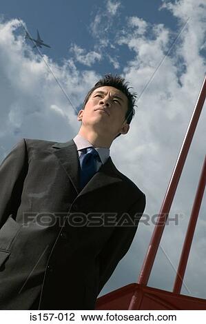 Stock Image - Businessman and cloudy sky. Fotosearch