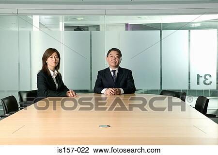 Stock Image - Businessman and woman in conference room. Fotosearch