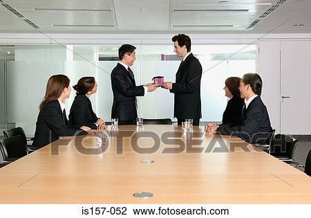 Stock Image - Businessman being handed a gift. Fotosearch