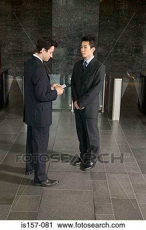 Stock Image - Businessmen exchanging business cards. Fotosearch
