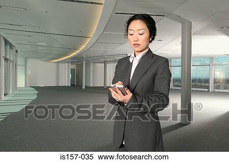 Businesswoman using a handheld computer View Large Photo Image Stock Photography - Businesswoman using a handheld computer. Fotosearch