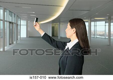 Businesswoman using camera telephone View Large Photo Image Stock Image - Businesswoman using camera telephone. Fotosearch