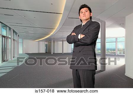 Serious looking businessman in office View Large Photo Image Stock Photo - Serious looking businessman in office. Fotosearch