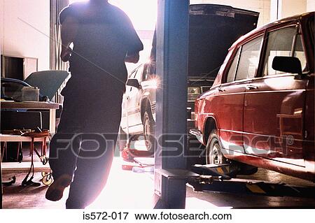 Mechanic running in garage View Large Photo Image Stock Photo - Mechanic running in garage. Fotosearch