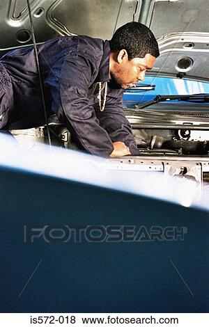 Stock Photo - Mechanic working on engine. Fotosearch
