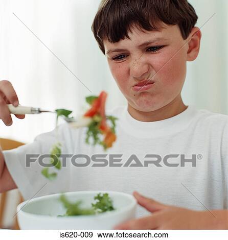 Boy looking disgusted at salad View Large Photo Image Stock Photo - Boy looking disgusted at salad. Fotosearch