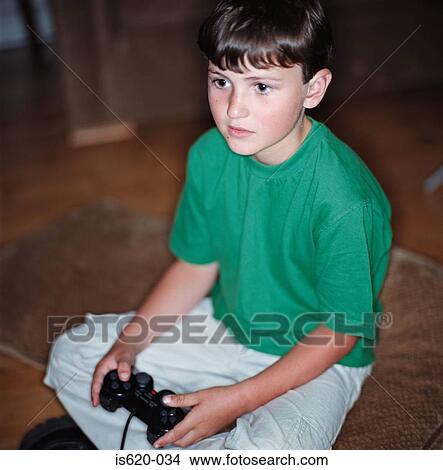 Boy playing a video game View Large Photo Image Picture - Boy playing a video game. Fotosearch