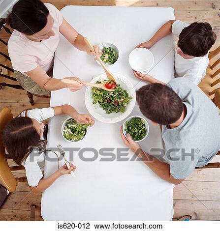 Family eating salad at table View Large Photo Image Stock Image - Family eating salad at table. Fotosearch