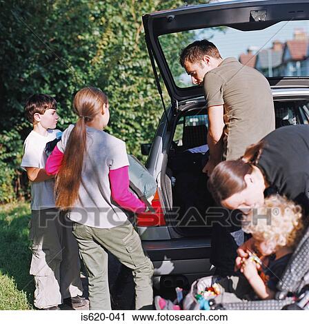 Stock Image - Family loading car for vacation. Fotosearch