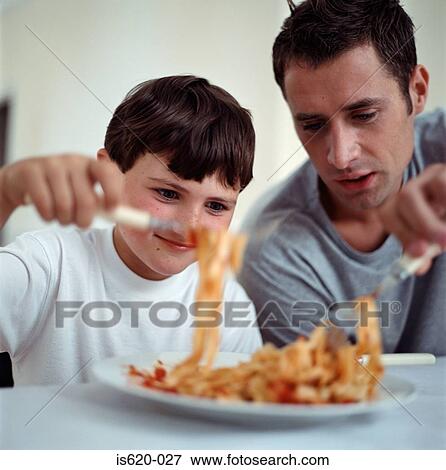 Father and son eating spaghetti View Large Photo Image Stock Photo - Father and son eating spaghetti. Fotosearch