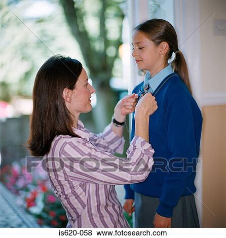 Woman dressing her daughter for school View Large Photo Image Stock Photo - Woman dressing her daughter for school. Fotosearch