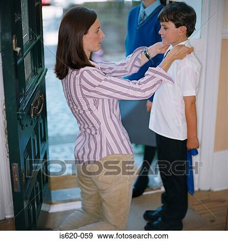Woman dressing her son for school View Large Photo Image Stock Photo - Woman dressing her son for school. Fotosearch