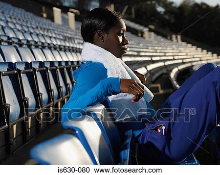 Athlete sitting in empty stadium View Large Photo Image Stock Image - Athlete sitting in empty stadium. Fotosearch