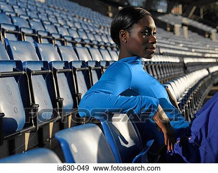 Stock Photo - Athlete sitting in empty stadium. Fotosearch