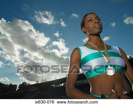 Stock Photograph - Female athlete wearing a medal. Fotosearch